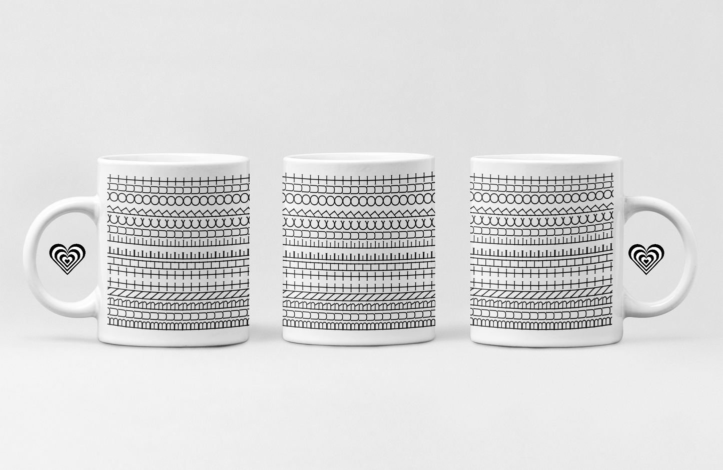 Three white mugs with black patterned designs on a light gray background