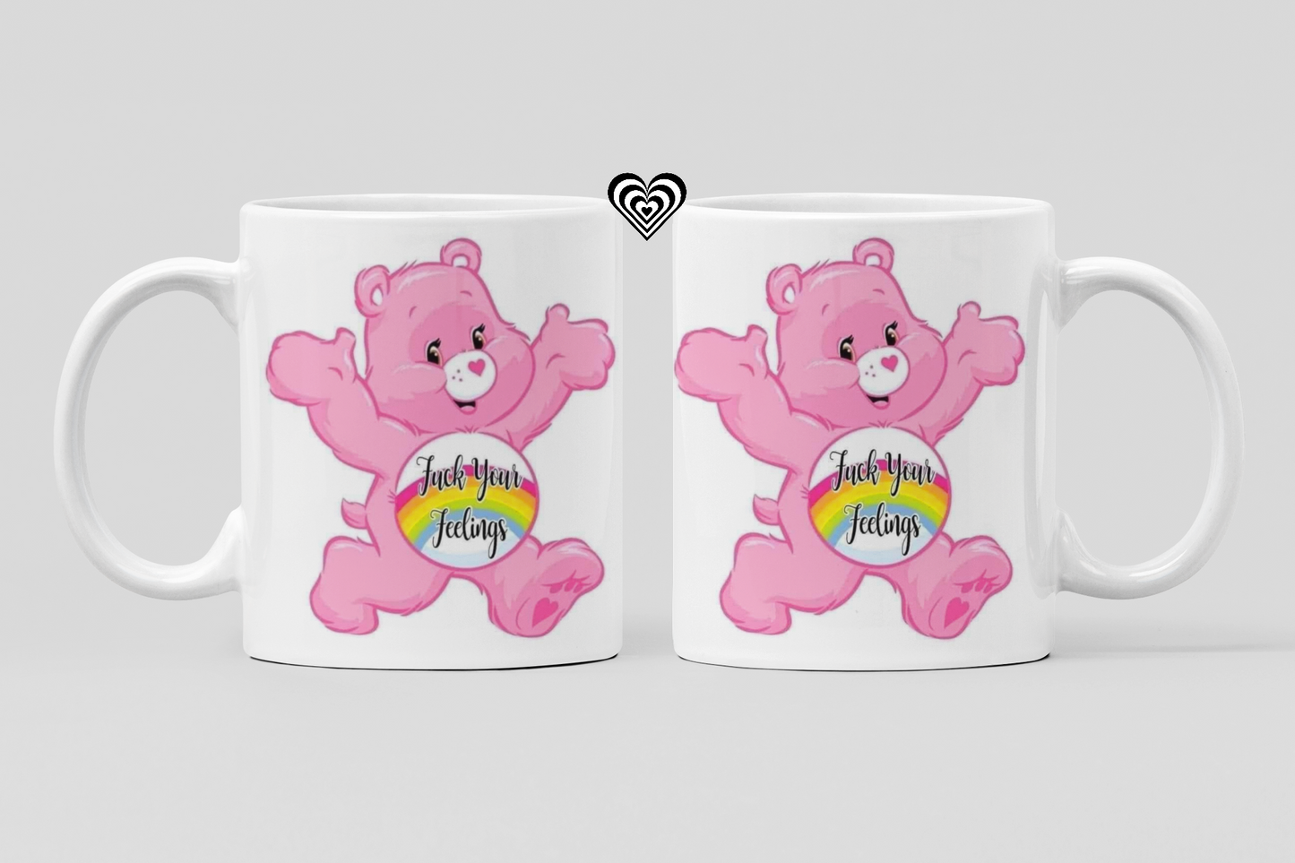 Two white mugs with pink cartoon bear characters and rainbow text "f*ck your feelings" on a light gray background.