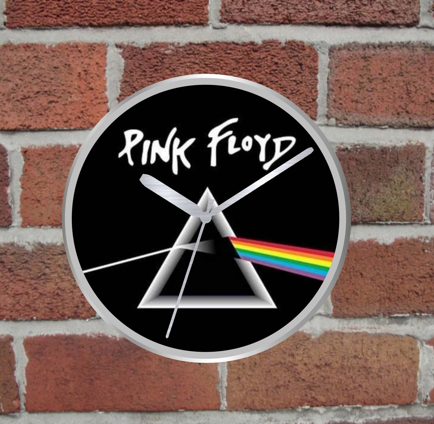 Pink Floyd silver wall clock with dark side of the moon design on a brick wall background