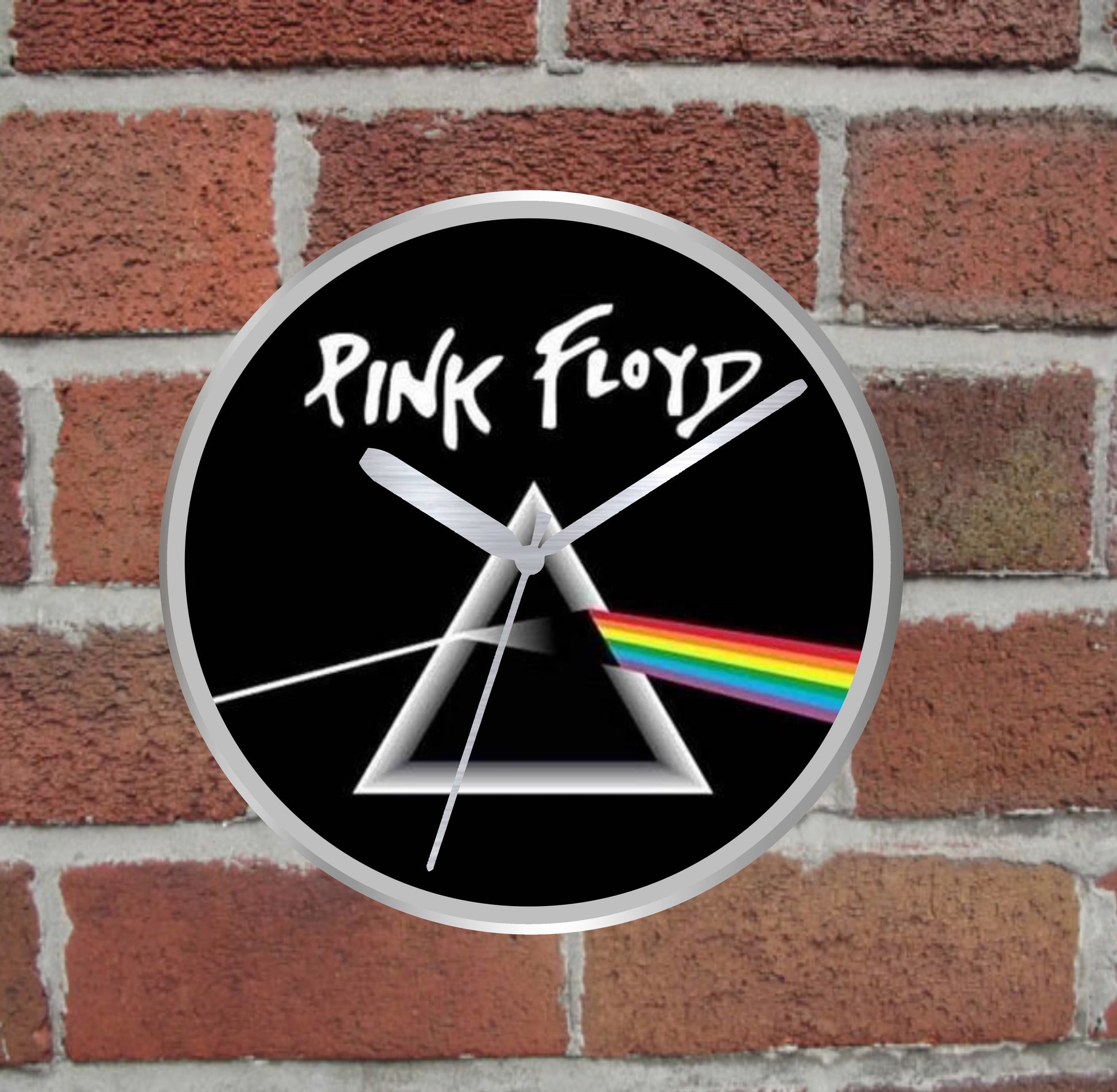 Pink Floyd silver wall clock with dark side of the moon design on a brick wall background