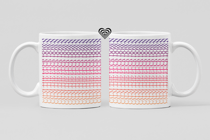 Two white mugs with colorful patterned designs on a light gray background