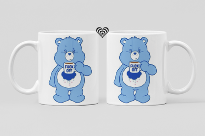 Two white mugs with blue cartoon bear designs and profane text on a light gray background.