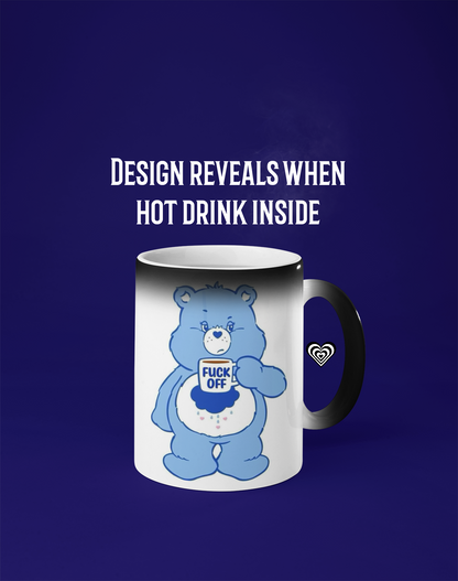 Mug with a cartoon bear design that changes color when hot, on a blue background.