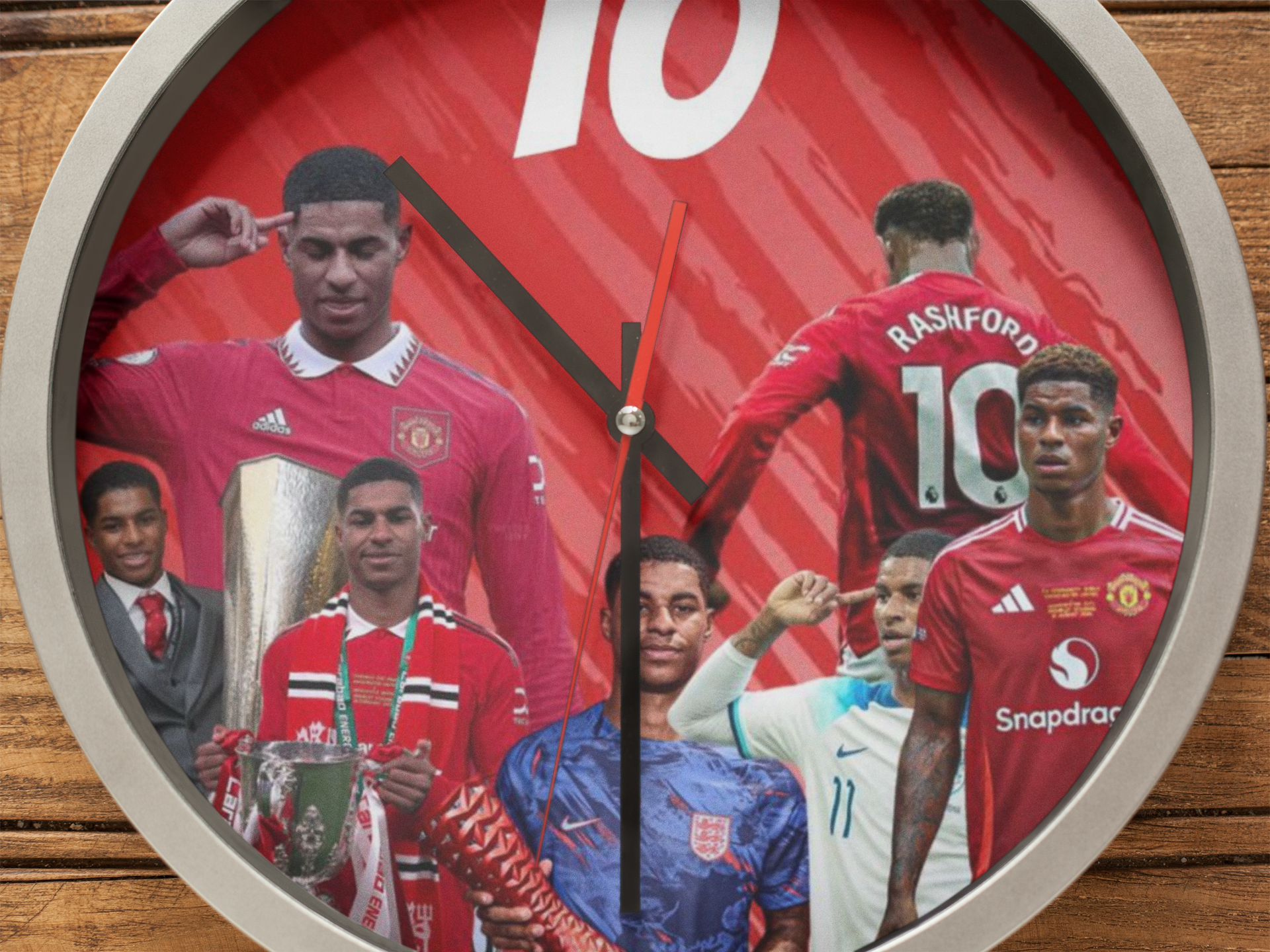 Wall clock with images of Rashford soccer player in a red jersey on a wooden background