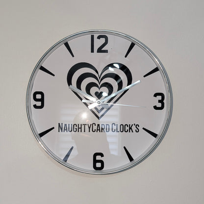 Silver Wall clock with heart design and 'NaughtyCard Clock's' branding on a plain background