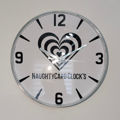 Wall clock with heart design and 'NAUGHTYCARD CLOCK'S' branding on a plain background
