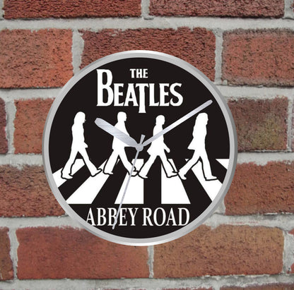 Circular 'Abbey Road' sign with The Beatles logo on a brick wall background
